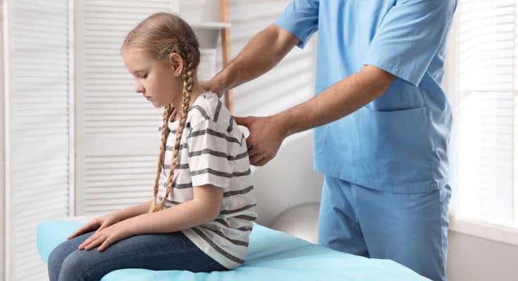 iPad posture for kids: a girl being examined by a chiropractor